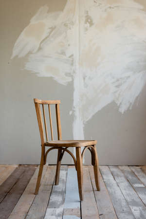 moving to a new apartment, the beginning of redecoration. wooden chair stands against the wall of the plasterboard.の写真素材