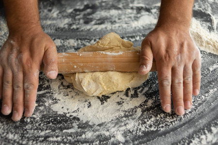 the chef rolls out the dough with a rolling pin, an ingredient for making pizza. space for text