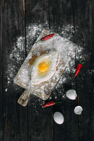 Raw Homemade Adjarian Khachapuri Stuffed with Raw Egg and Ghee. Fresh hot traditional Georgian boat-shaped cheese breadの写真素材