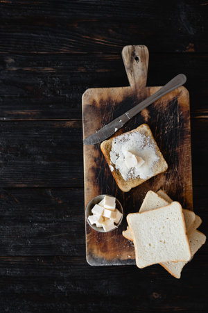 toasted piece of bread and butter, a cutting board, place for text. Tasty and nutritious breakfast
