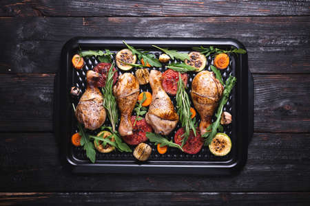 tasty and juicy pieces of meat baked in the oven, grilled vegetables, chicken legs, dinner for the family. crispy crustの写真素材