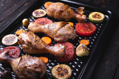 Fried chicken legs with vegetables on a plate, grilled vegetables. chicken meat close-up, crispの写真素材