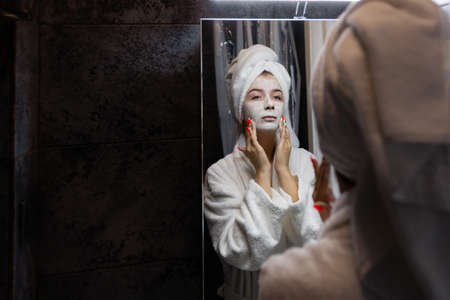 woman is doing facial treatment. basic principles of skin care cleansing moisturizing nutrition. girl does lifting massage.の写真素材