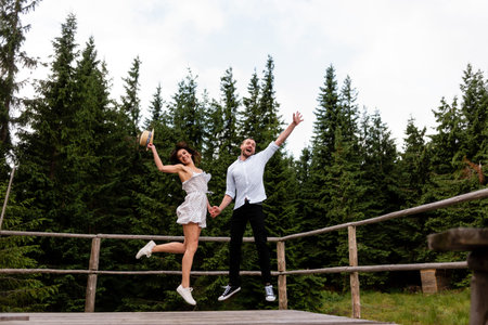 Man jumping on the wooden terrace and have forest background.