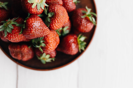 A large dish with ripe strawberries. View from above. Concept of summer mood and healthy eating.