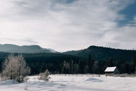 Cloudy sky over a snowy roof in a village located on the side of a mountain. Alps, Franceの写真素材