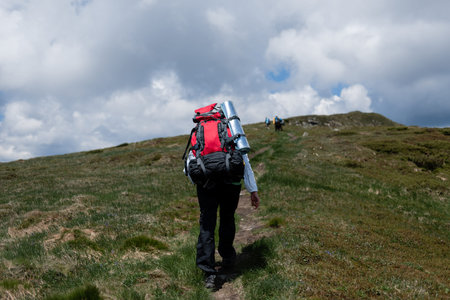 Group of hikers climbing up the mountain along the trail
