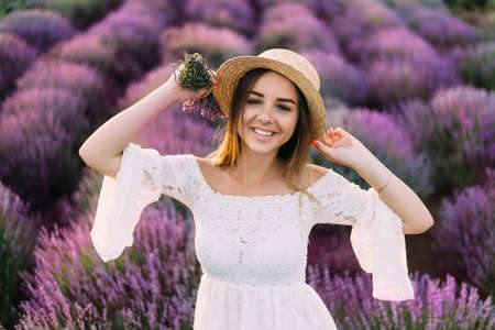 Portrait of happy woman in white dress against lavender field of Provence, France. Aromas of lavender flowers, Valensole plateau landscapes - ideal for authentic holidays loversの写真素材