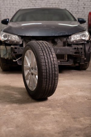 Photo of a car tire in the background of a car in the garage