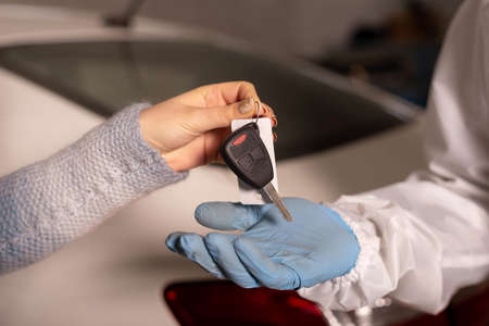 Closeup photo of handing over car keys after repair in a car service, concept of quality serviceの写真素材