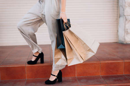 Portrait of woman after shopping. Beauty woman with shopping bags standing in shopping mall. Shopper, sales, shopping center. Copy spaceの写真素材