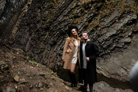 travelers in Iceland, a stylish young couple stands against a rocky wall, a place for text,の写真素材