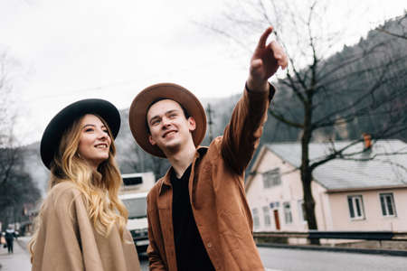 travel business, a guy with a girl during a vacation walks and he points a finger at something.の写真素材