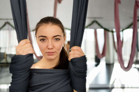 A closeup photo of a girl holding a black gymnastic ribbon in her hands. antagravity yoga to improve overall health.の写真素材
