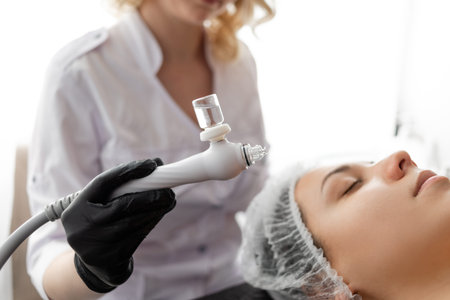 hardware cosmetology. the beautician holds in his hands a device that cleans the skin with a stream...