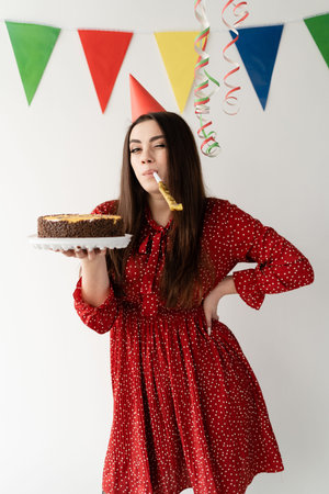 Happy birthday party. stylish and sexy girl holding a cake in her hands and is ready to congratulate...