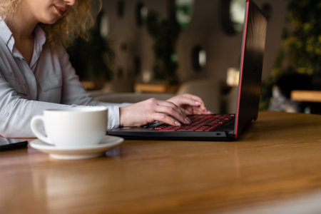 remote work at home, a young girl sits at home at a table and works at her laptop. Place for text