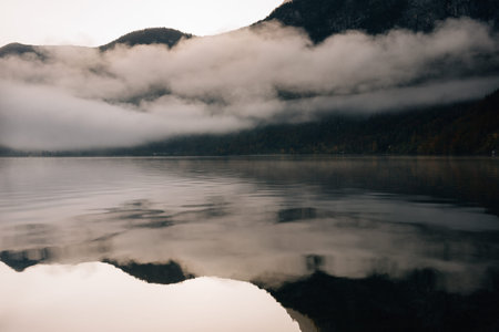 Misty morning on a mountain lake. High mountains with glacier, cold lake and fog. Thick fog swirls...