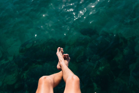 male legs on the background of the ocean. Rest at the resort in the summer. Place for text