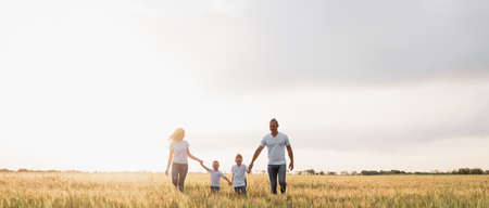 Silhouette, happy children with mother and father, family at sunset, summer. Two sons and parents. Camping. Place for textの写真素材