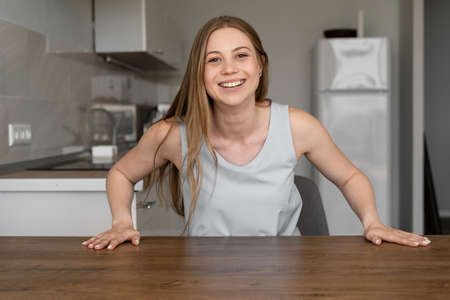 Smiling woman makes video call in her kitchen. Online chat, video communication, modern technologies conceptの写真素材