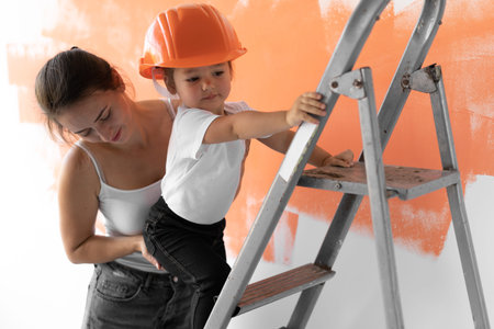 mom helps little daughter to climb the stairs. Home renovation concept. Close-up.