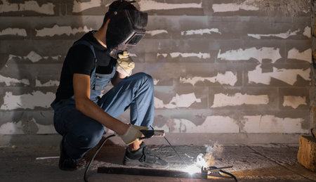 Welder working a welding metal with protective mask and sparks. Copy space.
