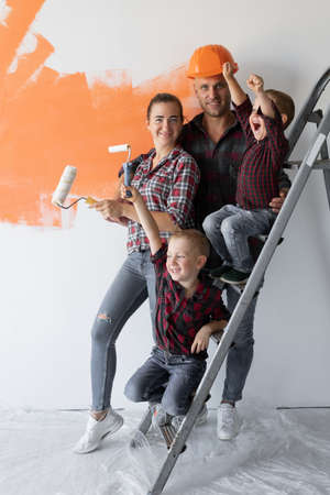 big family four people mom dad and two boys are sitting on the stairs. Home renovation conceptの写真素材