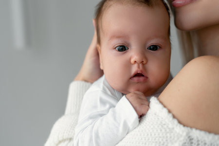 Portrait of a newborn on the shoulder of mom. The tenderness of my mother's hands and a beautiful...