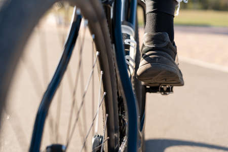 Cropped shot of man in sneakers riding a bicycle, feet on pedals. Copy space.の写真素材