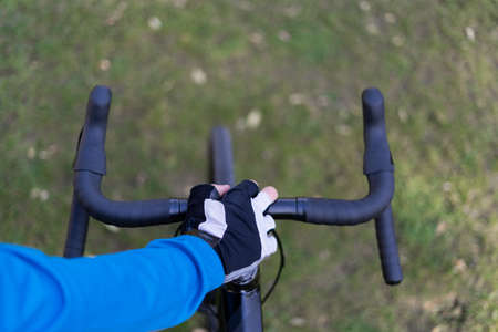 Close up of the handlebars of a bicycle top view. A man's hand holds it. copy spaceの写真素材