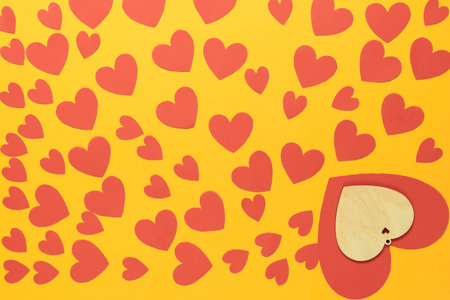 top view on a yellow background there are many small red hearts. valentines day concept.