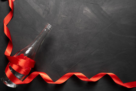 Empty bottle of champagne in a red ribbon. Valentines Day. On a concrete background.の写真素材