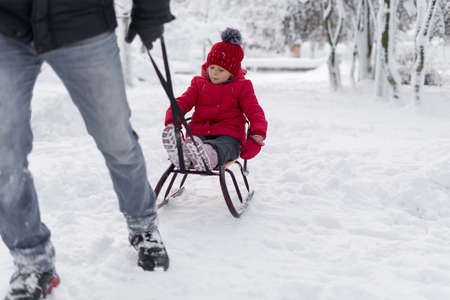 Handsome young dad and his little cute daughter are having fun outdoor in winter. Enjoying spending time together. Family concept.の写真素材