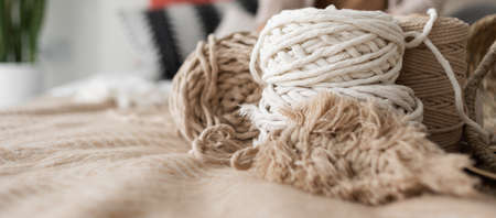 on the bed are two macrame rope skewers. Weaving macrame. Accessories in the form of macrame twine are lying on the bed. Banerの写真素材