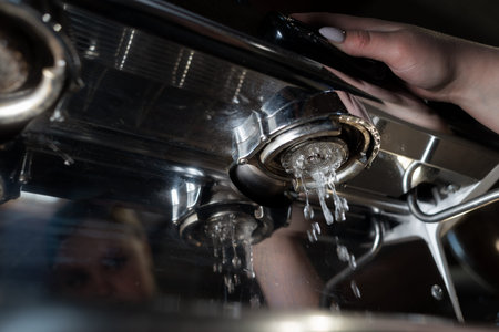 Water flows out of the machine. Close up photo. Professional coffee machine in the cafe. Chrome or stainless steel parts. Water drops.の写真素材
