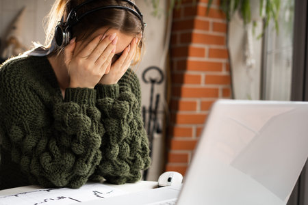 sick business lady with headache working remotely in a cafe with a laptop online. Stress and fatigue...