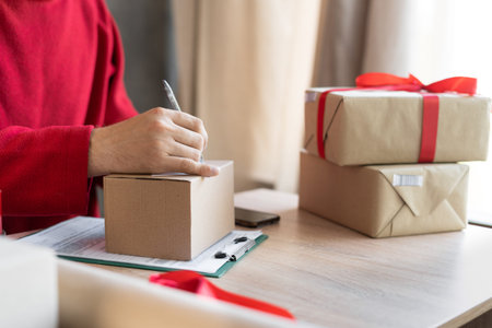 close-up of male hands filling out a mailing form on a parcel box in the office or at home. small...