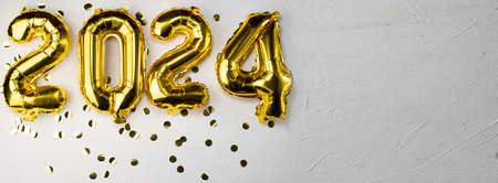 gold foil new year balloons 2024. New Years digit number two thousand twenty four. Golden on a gray concrete background.banner.place for textの写真素材