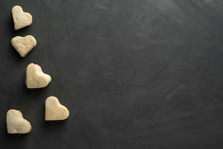 Heart cookies on a black background a symbol of love for the holiday Valentines Day. Homemade cakes for the holiday. The concept of baking for the holidays.の写真素材