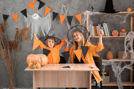 mom and daughter made a garland of orange and black flags for Halloween at home with their own hands.の写真素材