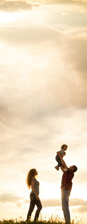 family mom dad and little son at sunset. Silhouettes of parents and child against the sky. Freedom and an active lifestyle. family relationshipsの写真素材