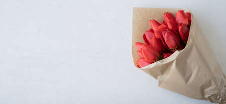 Bouquet of red tulips isolated on a white background in craft paper. Spring and summer background. Mothers Day Valentines Day Womens Dayの写真素材