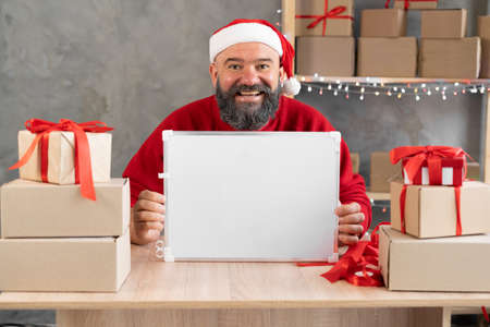 entrepreneur santa increases revenue share and customer marketing, sales dashboard. Christmas warehouse and postal shopping. A man in a home officeの写真素材