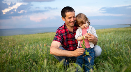 Father holds his little son tightly while walking in the evening at sunset. Happy family dad and son on the blue sky background field. Time togetherの写真素材