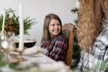 Smiling little girl with mom have Christmas breakfast at home. Family Christmas. Home x-mas conceptの写真素材
