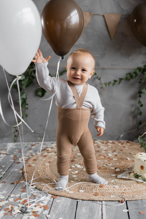 First birthday of the child, happy one year old toddler with balls. Rustic style childrens birthday concept.の写真素材