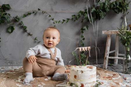 holiday babys first birthday, boy with a delicious cake sitting on the floor, birthday in rustic style, natural photo zone, happy one year old.の写真素材