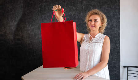 shopping in a clothing store, a woman seller giving a shopping package, selling and buying clothes. Shopping conceptの写真素材
