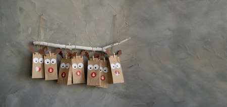 handmade advent calendar with paper bags and stickers hanging on the wall, christmas retro background, new year surprise.の写真素材